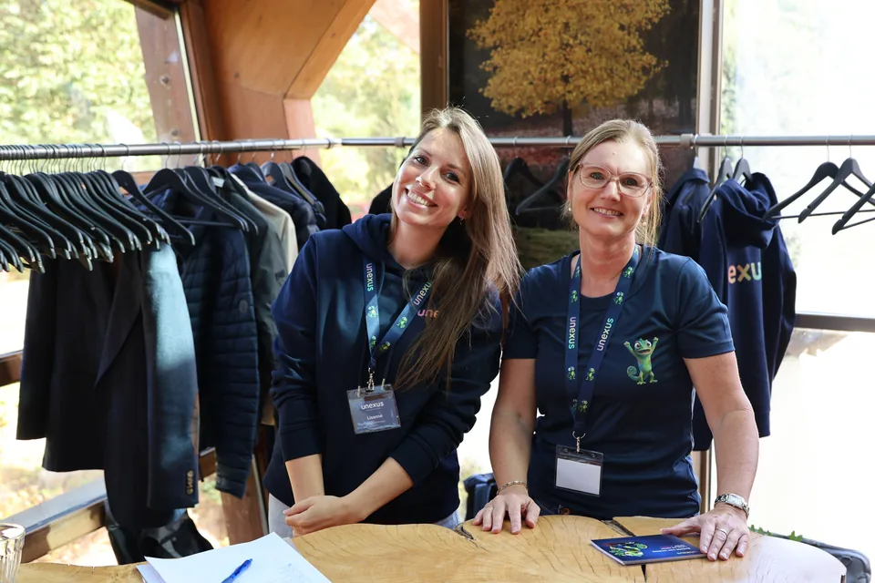 Twee collega&rsquo;s achter de stand met Unexus-kleding