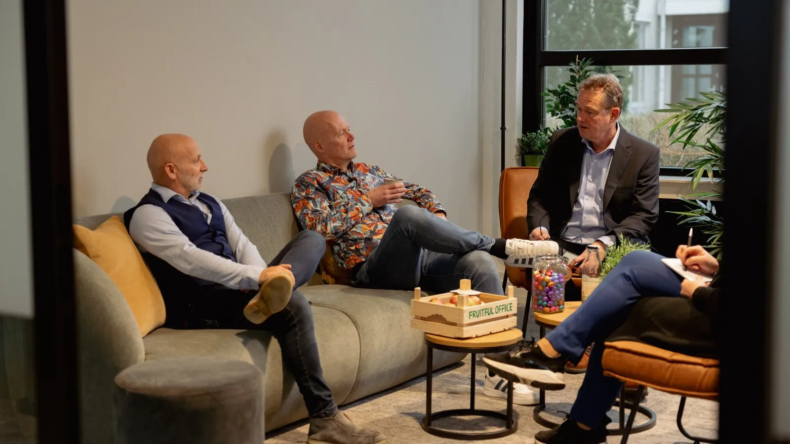 Drie collega’s in gesprek in de zithoek van het kantoor