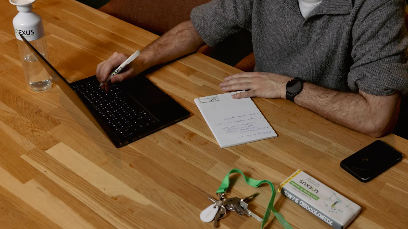 A notepad with handwritten notes beside a laptop on a desk