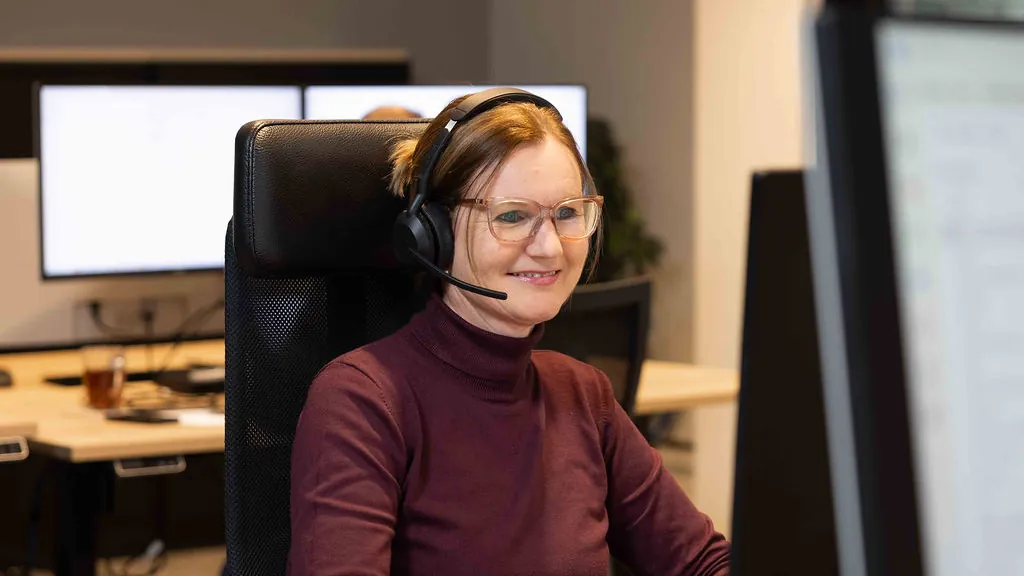 En kollega ved servicedesken med headset