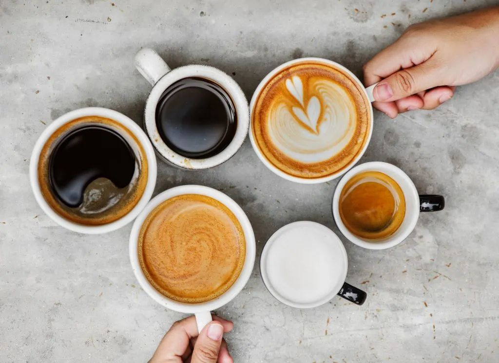 Kopjes koffie, cappucino en espresso worden met twee handen gedeeld.