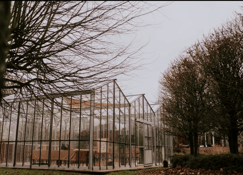 Het Groene Huis van buiten, een glazen kas tussen kale bomen
